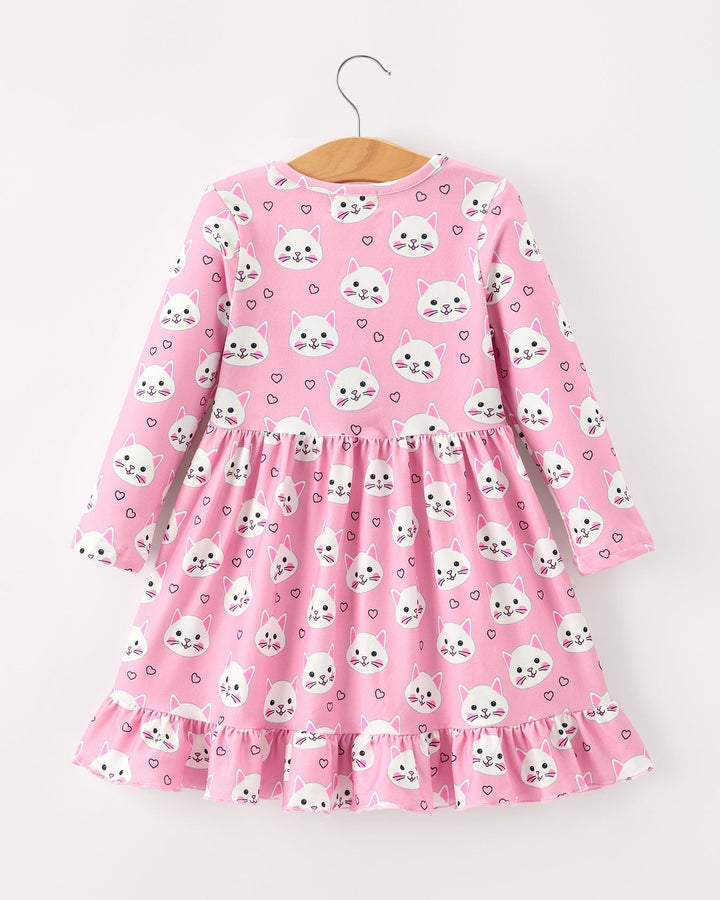 Pink dress with white animal print on a hanger against a white background