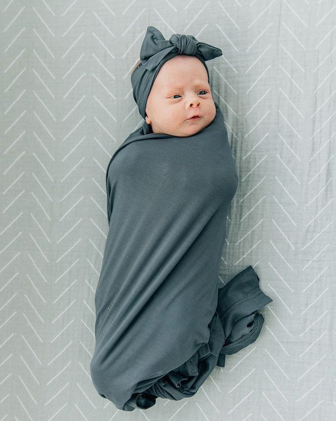 Charcoal-gray bamboo head wrap on a baby, tied bow on top