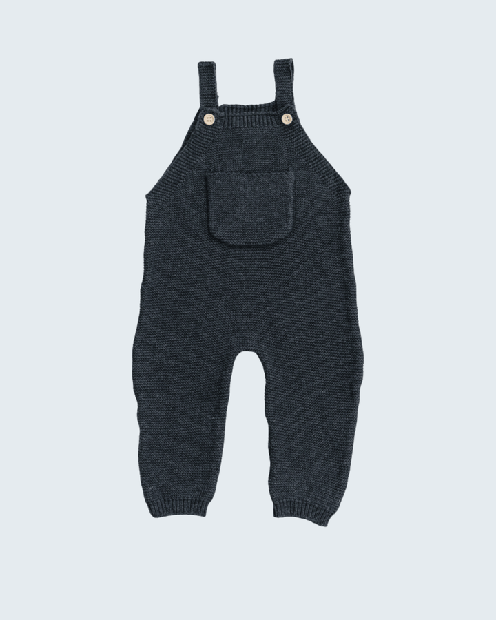 A dark charcoal gray knit baby overall romper with adjustable shoulder straps, a front patch pocket, and two small gold-tone snap buttons, shown against a light gray background.