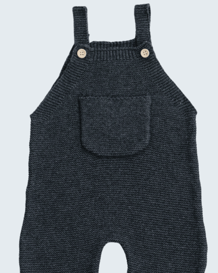 A pair of dark grey knit baby overalls with adjustable shoulder straps, two wooden buttons, and a front patch pocket, shown against a light gray background.