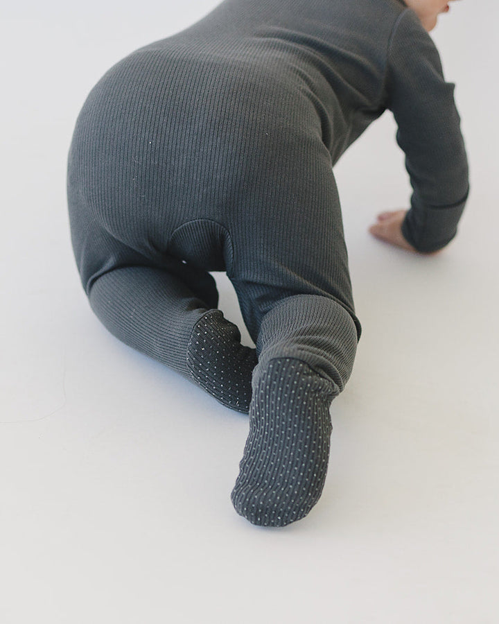 Charcoal ribbed cotton zipper romper on baby, kneeling pose with covered foot