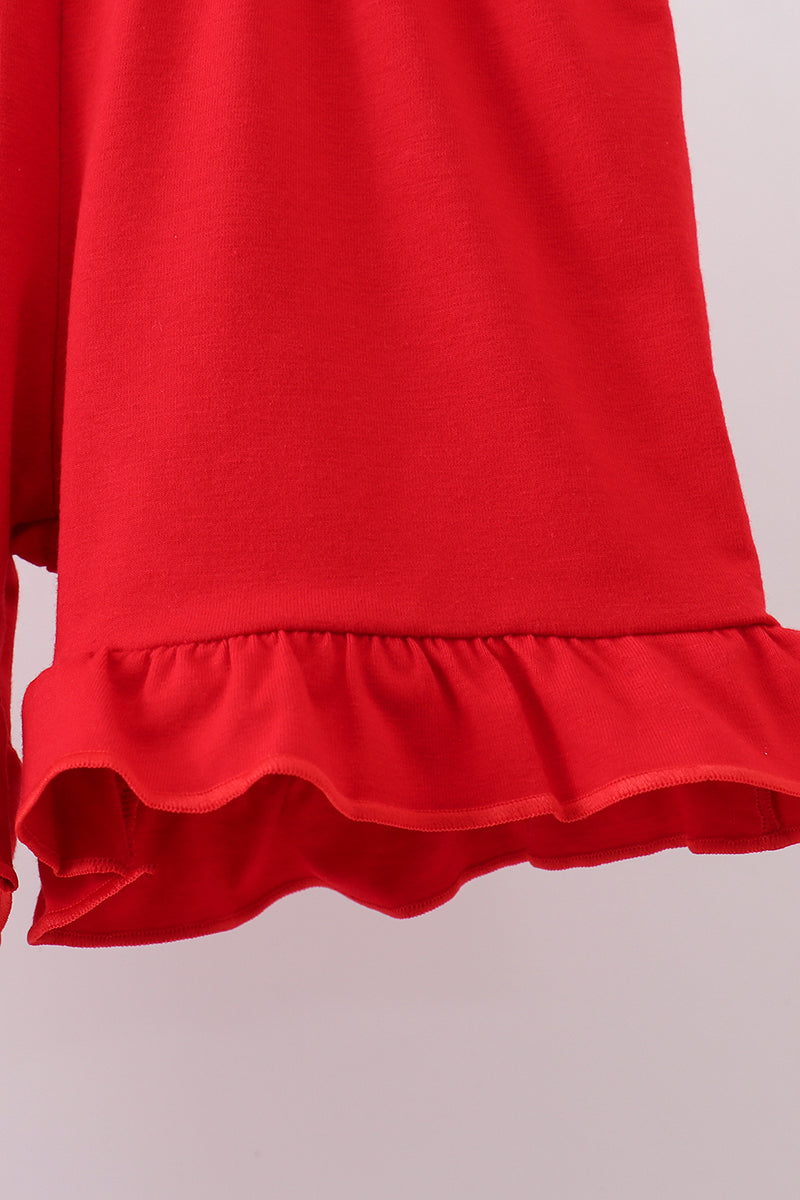 Red shorts with a ruffled hem on a light gray background