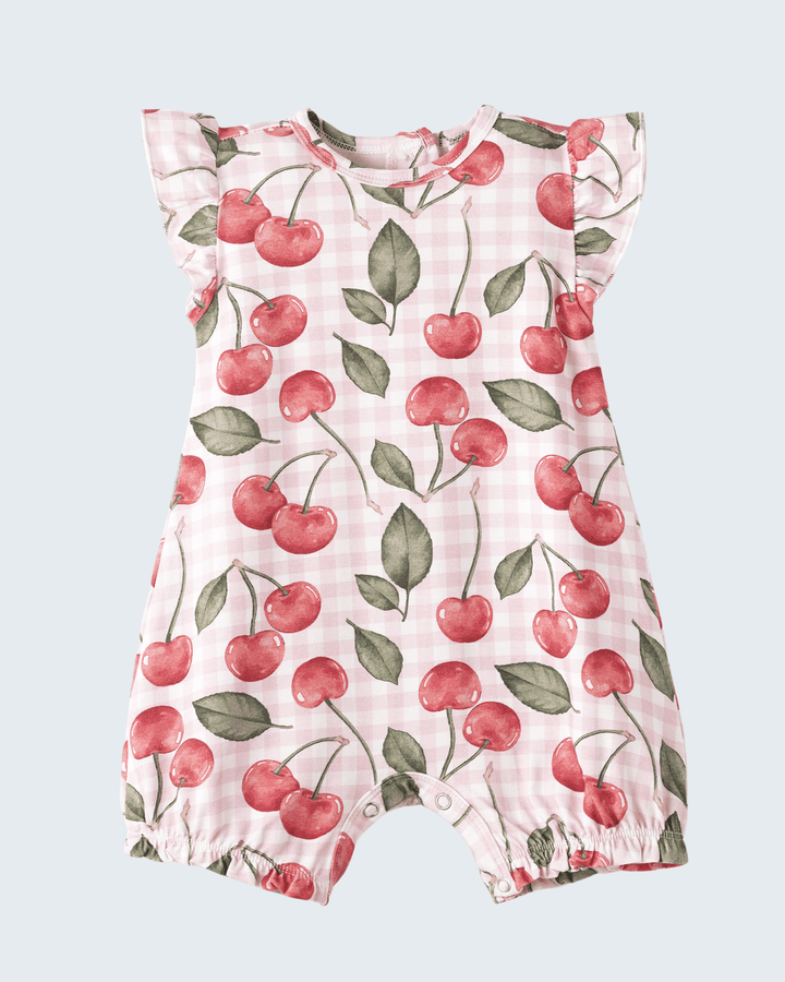 Baby romper with cherry pattern on a light blue background