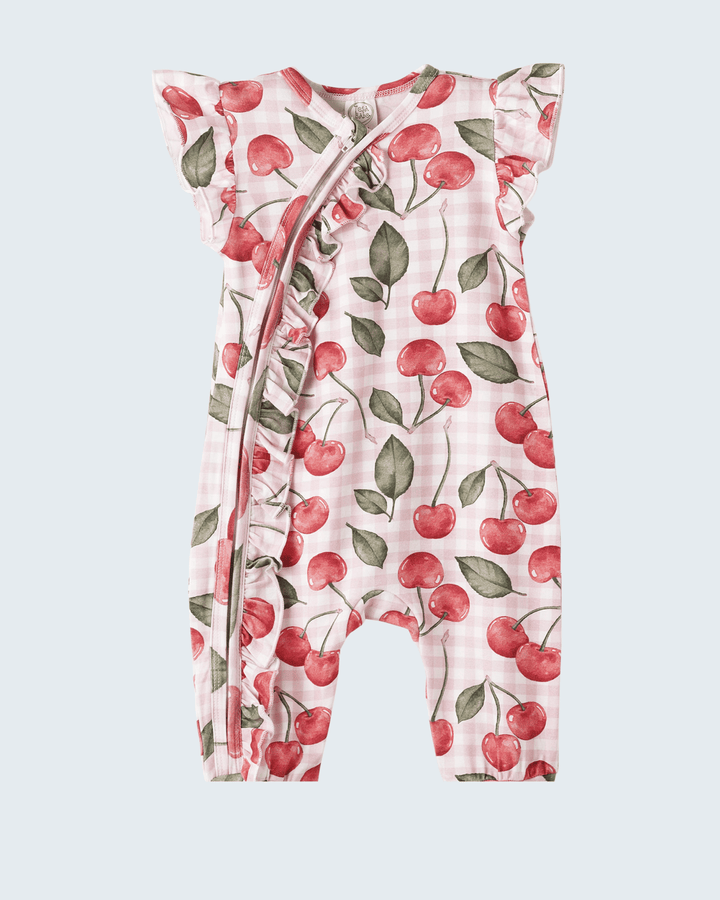Baby romper with cherry pattern on a light gray background