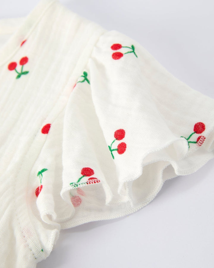 White fabric with red cherry patterns on a light gray background