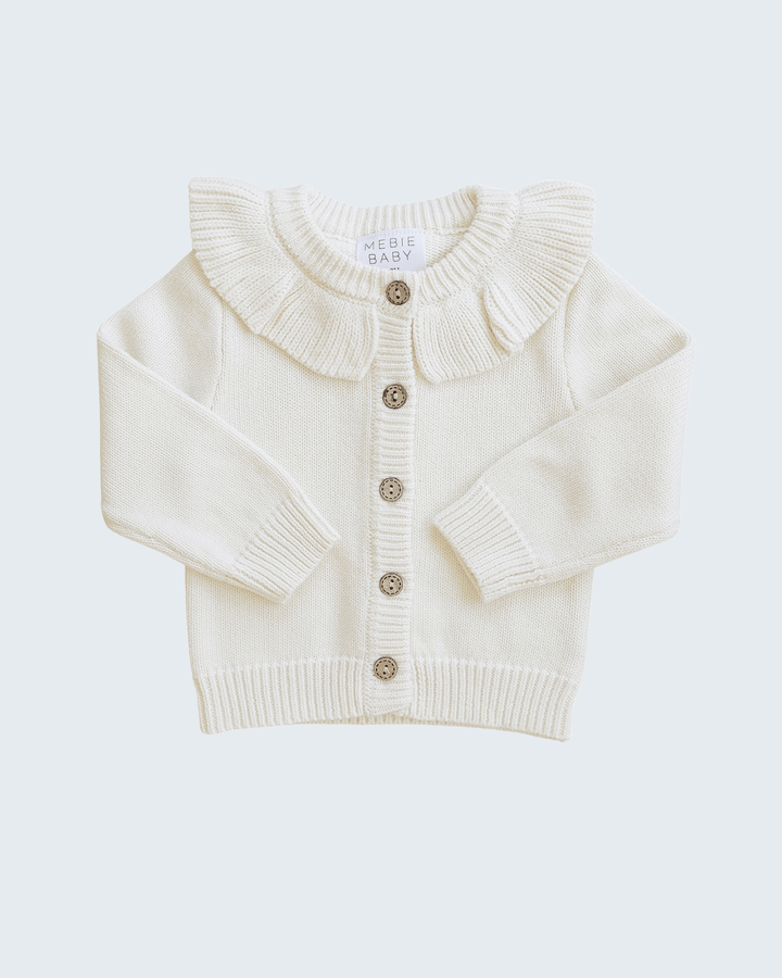Cream knit cardigan with ruffle shoulder collar and three-button front