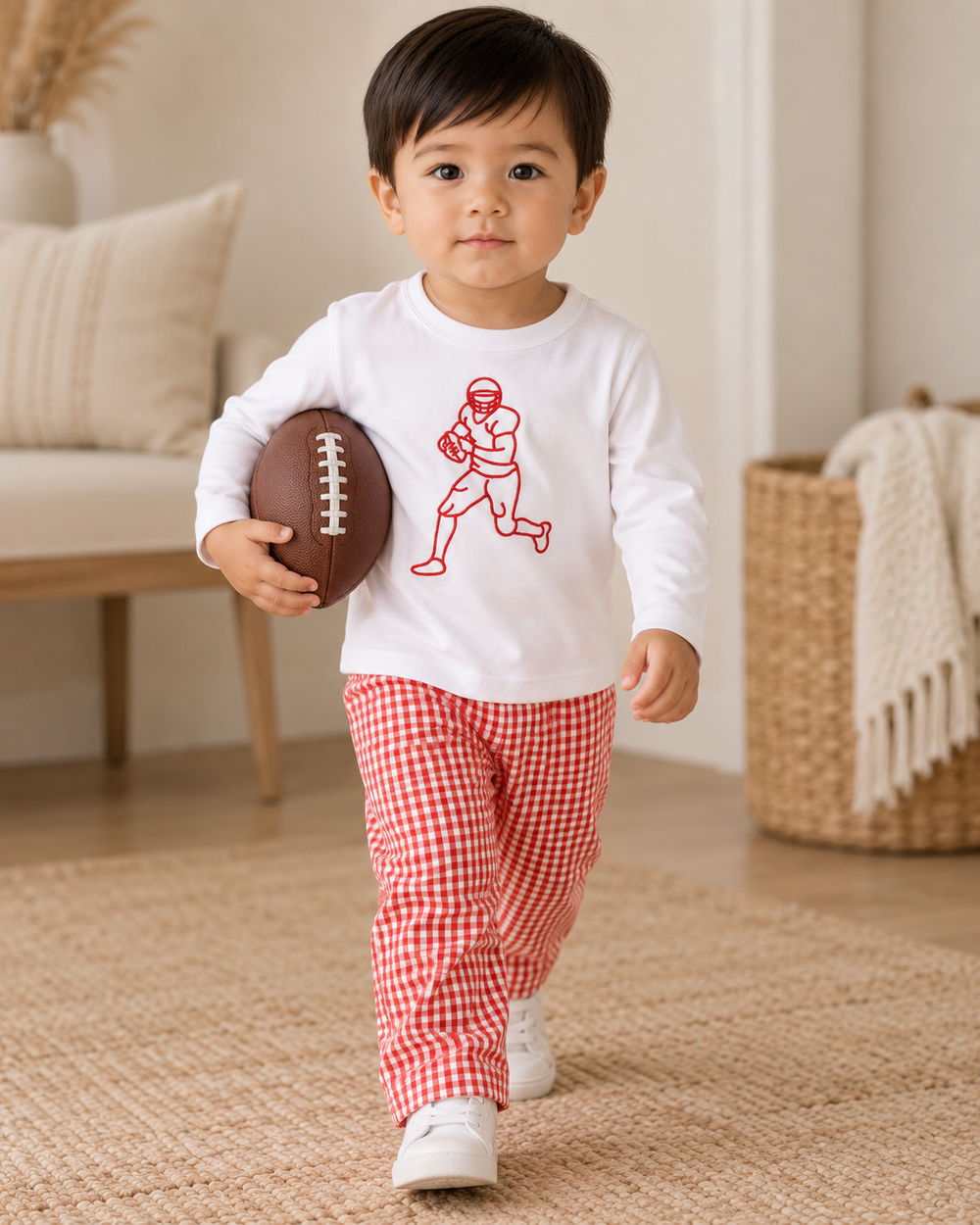 Toddler wearing white shirt with red football player print and red gingham pants