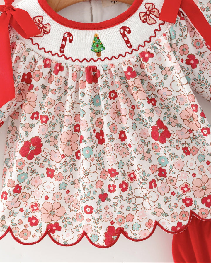Floral baby girl top with embroidered red trim, bow shoulders, and scalloped collar