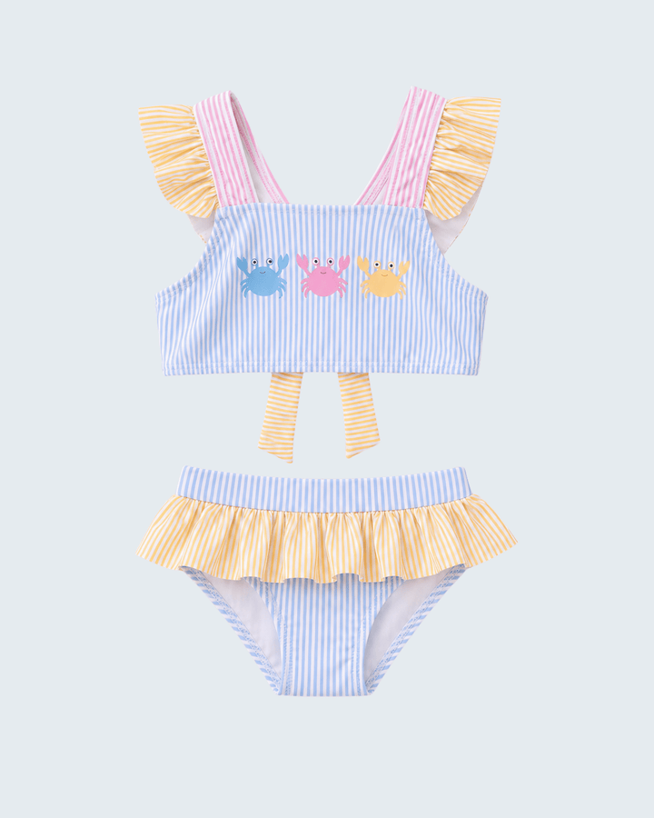 Two-piece swimsuit with ruffled details and cartoon designs on a light gray background