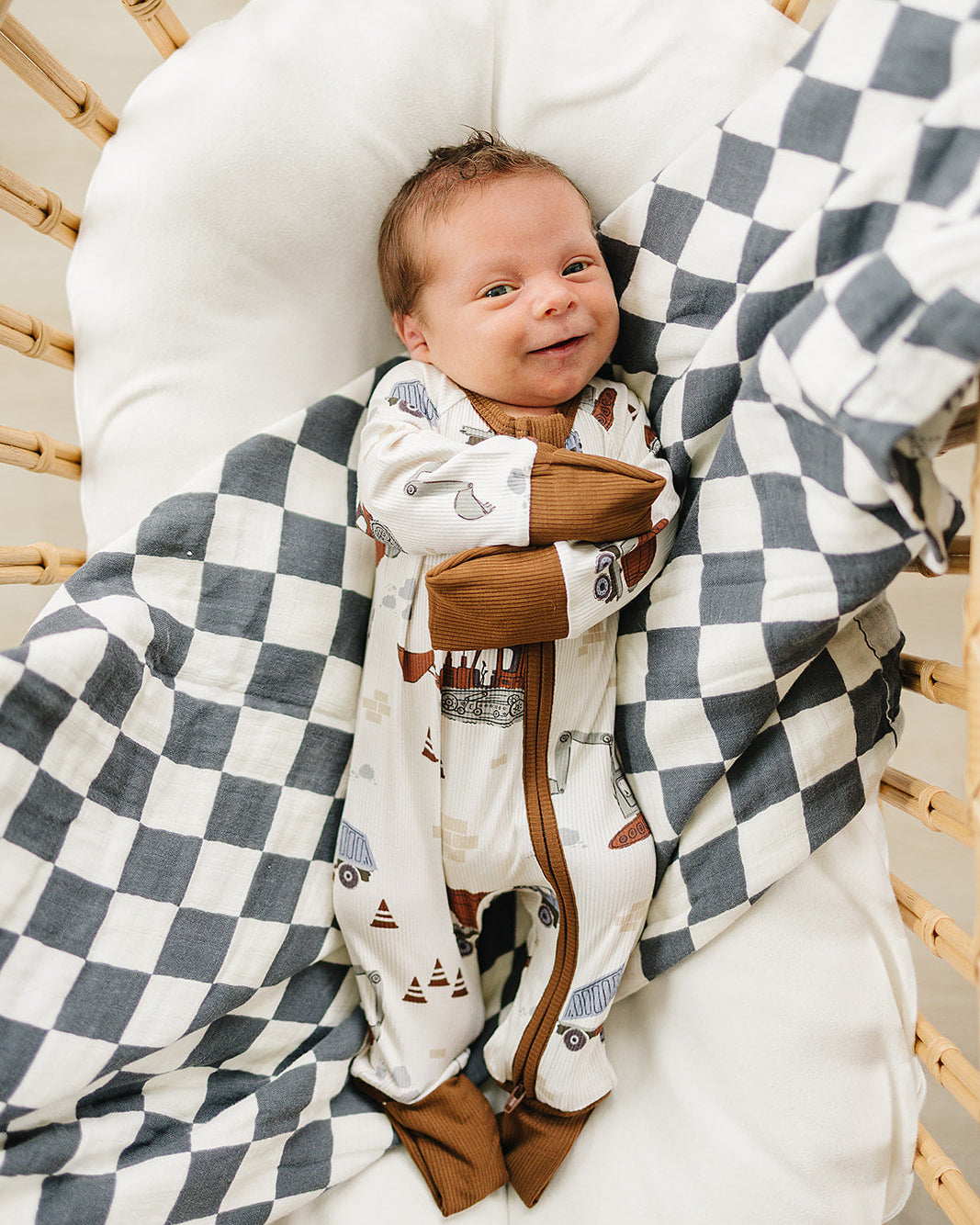 Baby in a crib with a checkered blanket