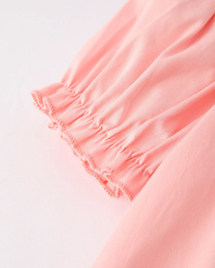 Close-up of a pink dress with a white background