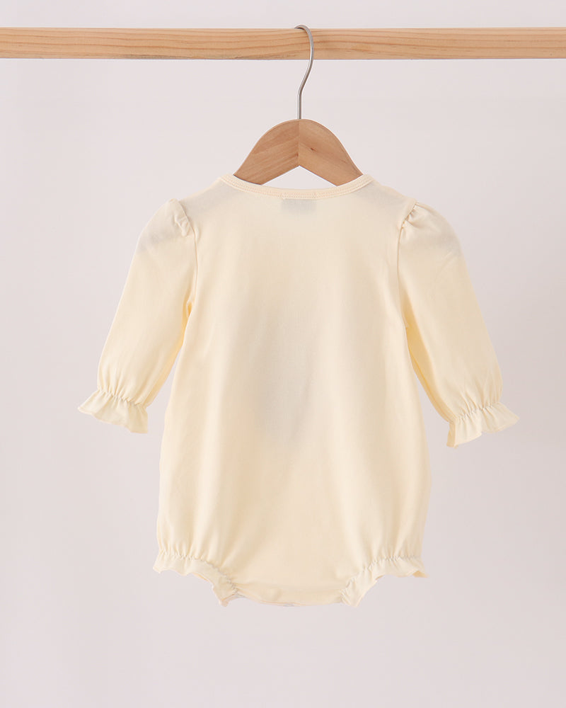 Cream long-sleeve baby romper with gathered cuffs and leg openings, back view
