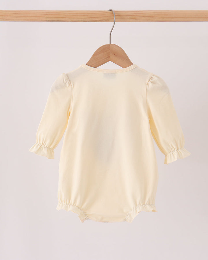 Cream long-sleeve baby romper with gathered cuffs and leg openings, back view