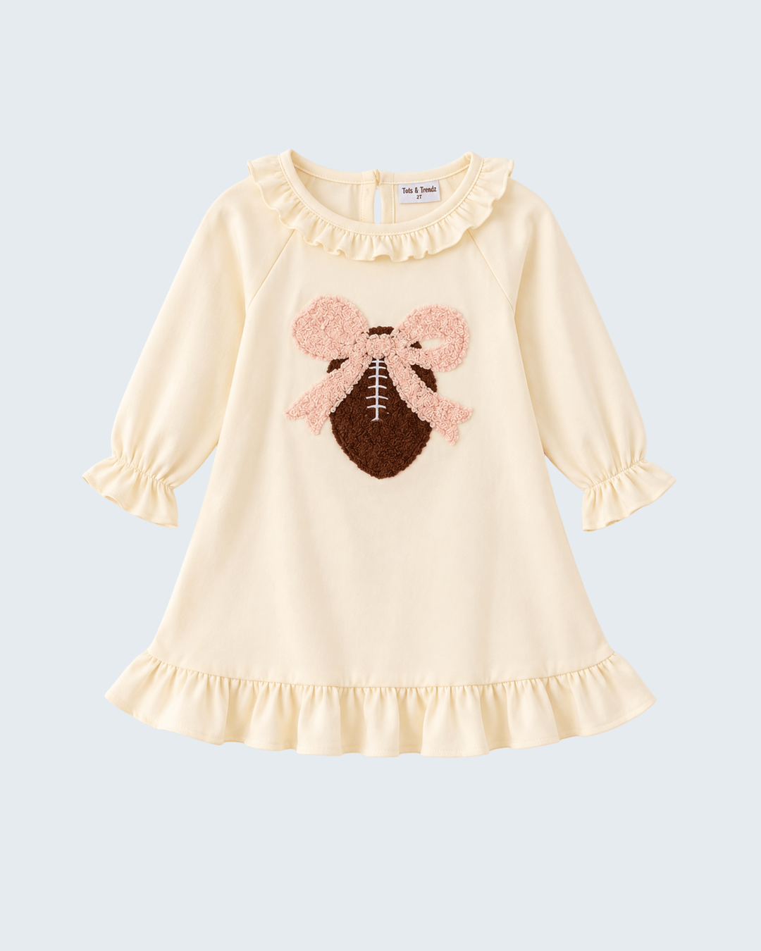 Cream ruffle dress with long sleeves and fuzzy football applique with pink bow