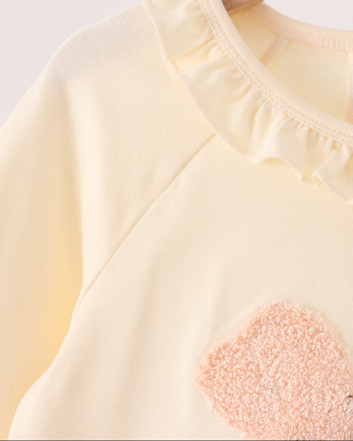 Cream dress with ruffled round neckline and stitched seam detail