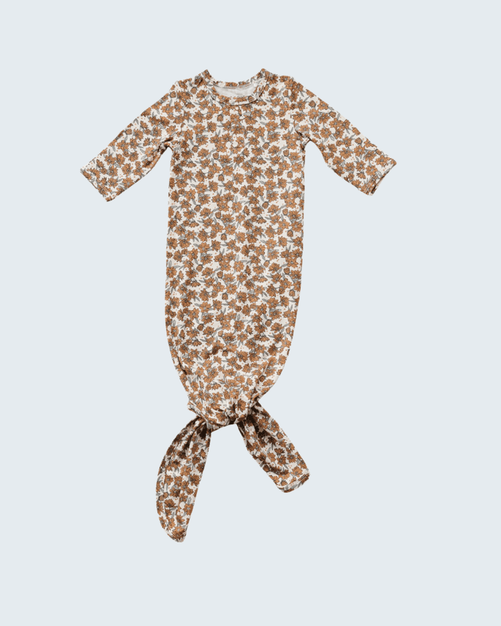 Baby gown with brown and white pattern on a light gray background