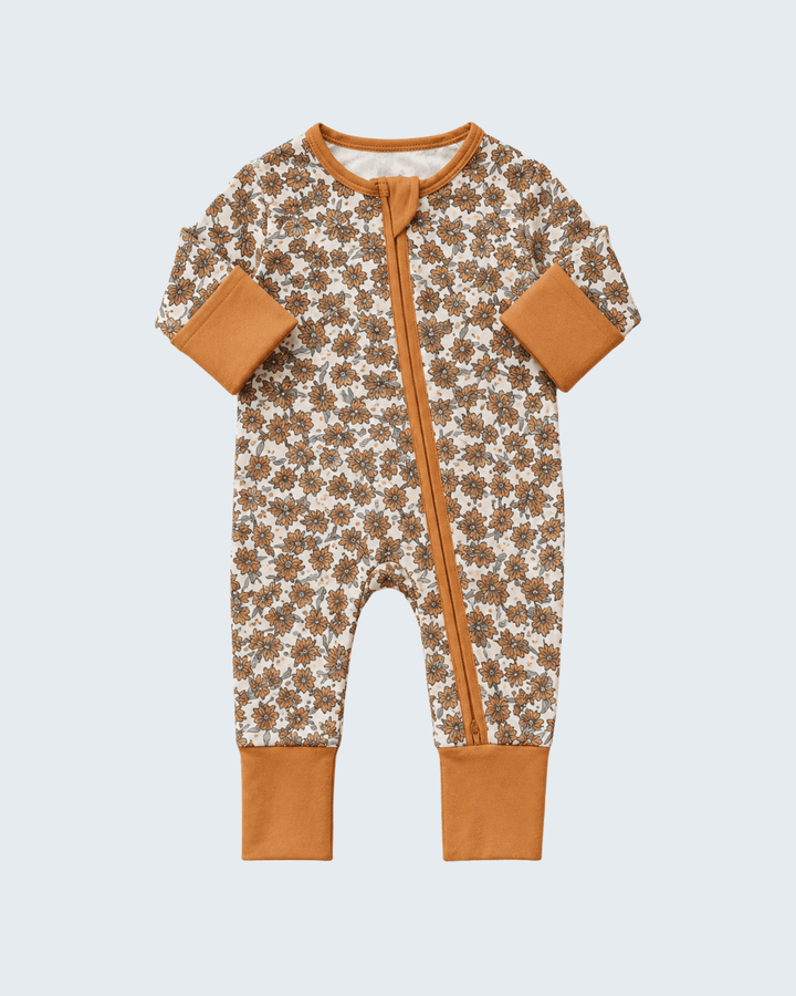 Cream floral bamboo zipper romper with long sleeves, front zip, tan cuffs