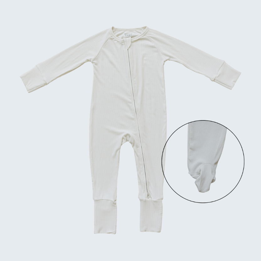 White baby onesie on a light gray background with a close-up of the foot area.