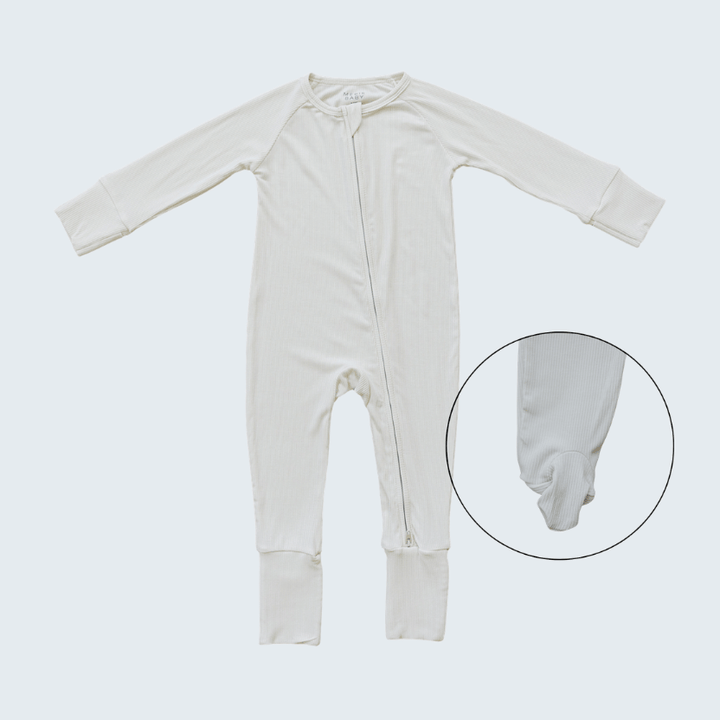 White baby onesie on a light gray background with a close-up of the foot area.