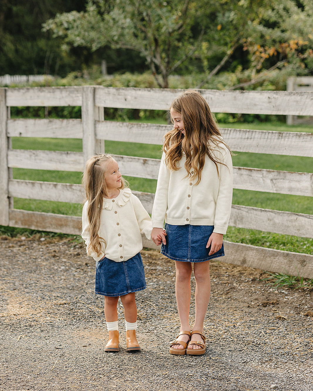 Cream knit ruffle cardigan, button front and long sleeves, worn with a denim skirt