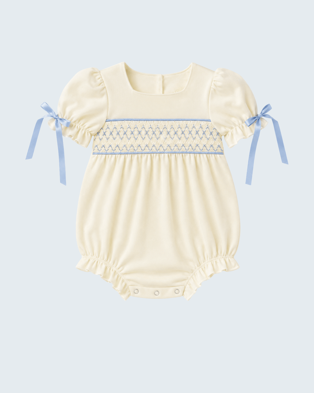 Cream smocked baby romper with blue trim and puff sleeves, snap legs