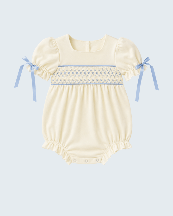 Cream smocked baby romper with blue trim and puff sleeves, snap legs