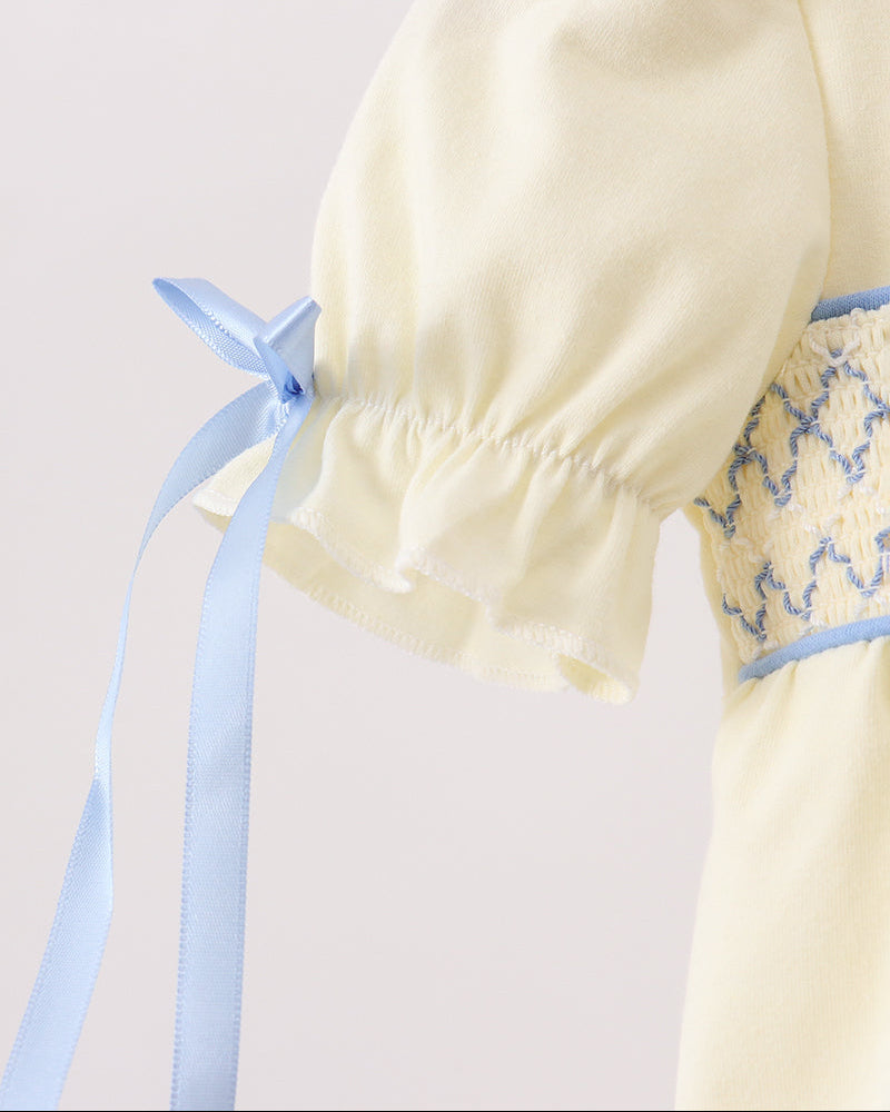 Cream puff-sleeve romper with blue ribbon tie and gathered elastic cuff