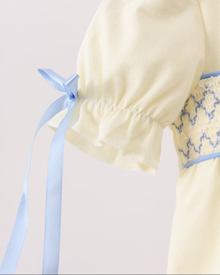 Cream puff-sleeve romper with blue ribbon tie and gathered elastic cuff