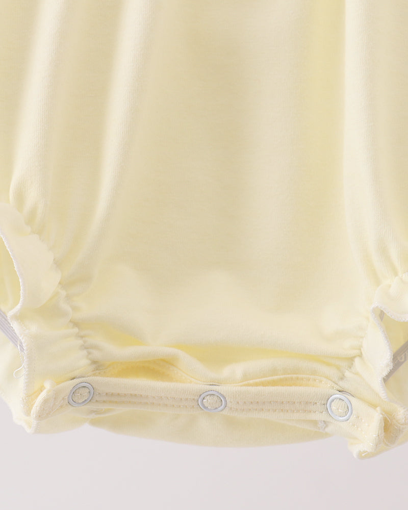 Cream bubble romper with snap-button leg opening and gathered waist seams