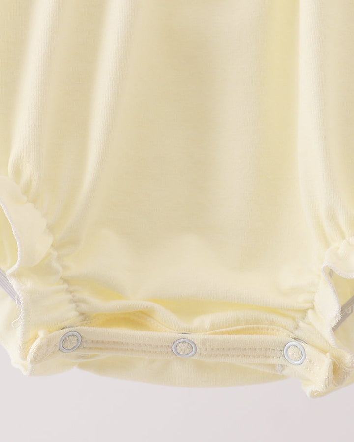 Cream bubble romper with snap-button leg opening and gathered waist seams