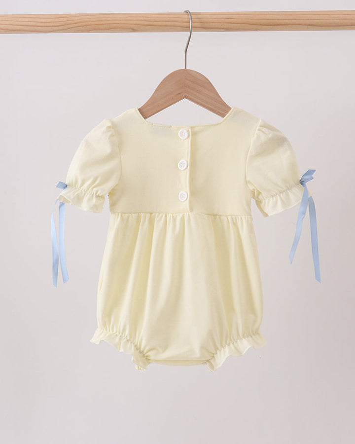 Cream bubble romper with front button placket and bow-tied puff sleeves, elastic legs