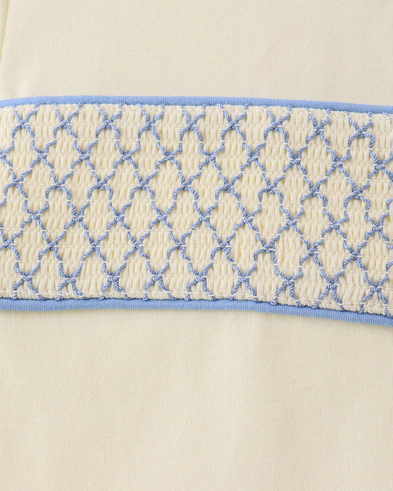 Smocked waistband detail in blue and cream on light blue pants
