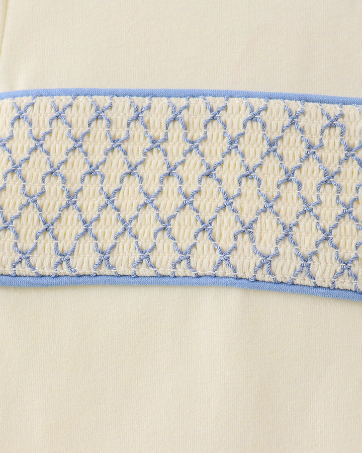 Smocked waistband detail in blue and cream on light blue pants