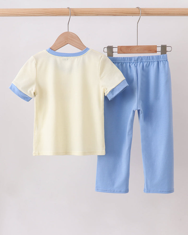 Cream short-sleeve shirt with blue-trimmed yoke and light blue smocked pants