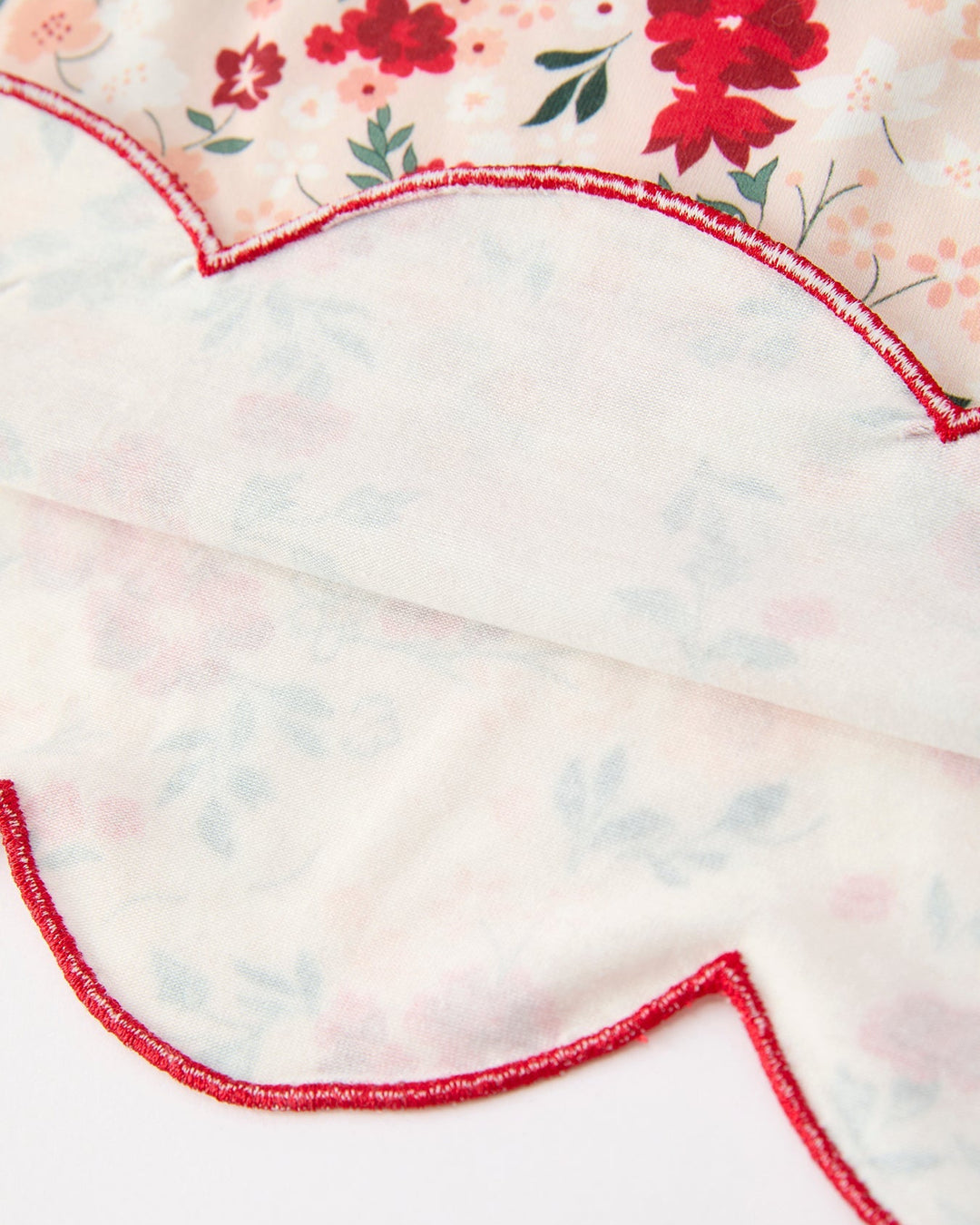 Girls floral twirl dress hem with scalloped edge and red piping