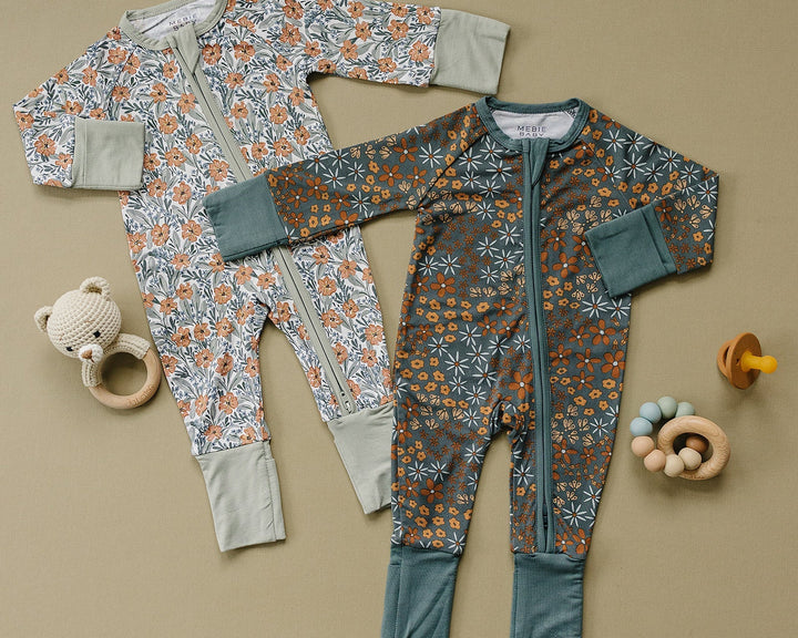 Two baby rompers with floral patterns on a beige background