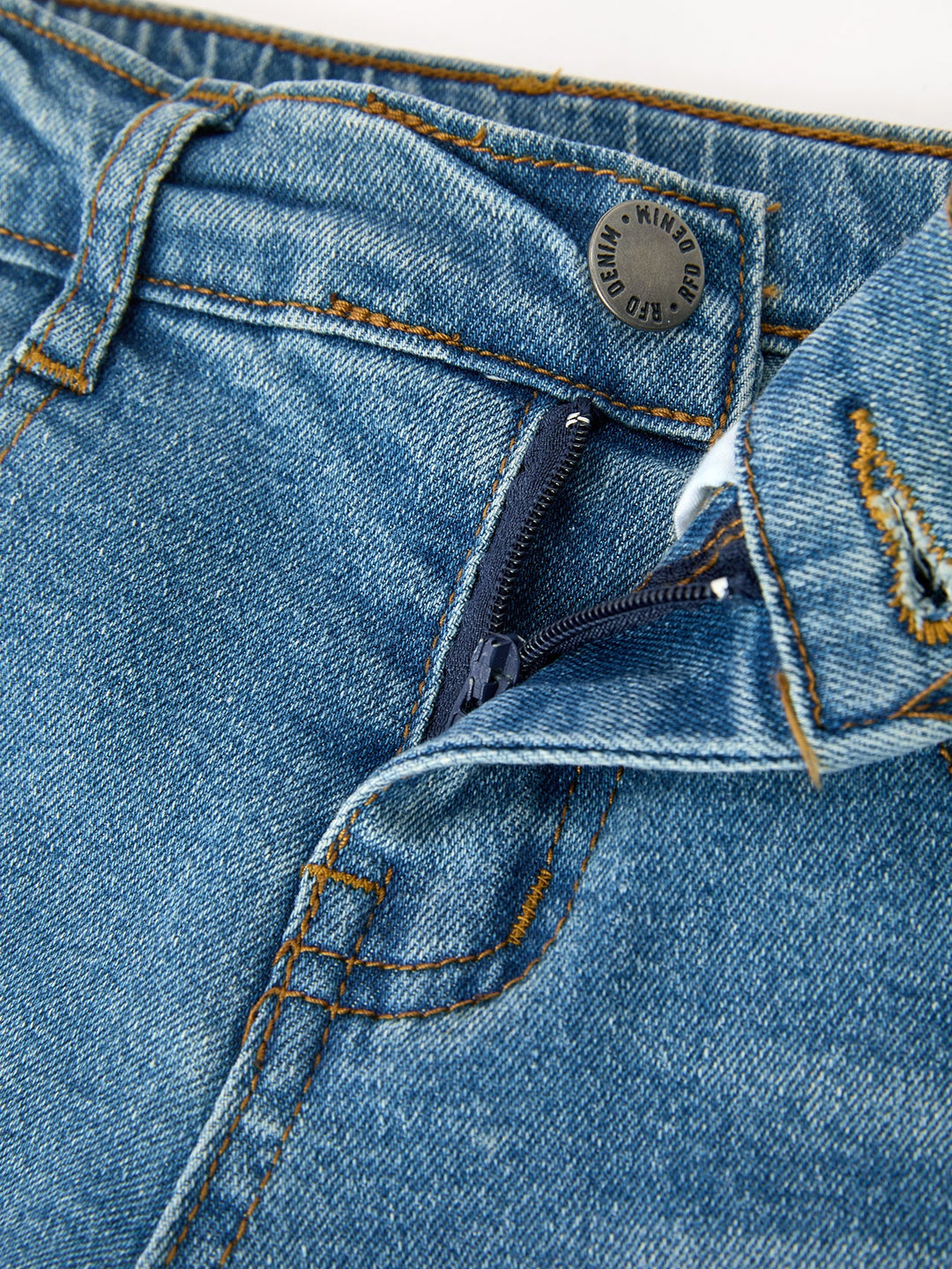 Girls denim jeans close-up of waistband, button fly, and stitched pocket