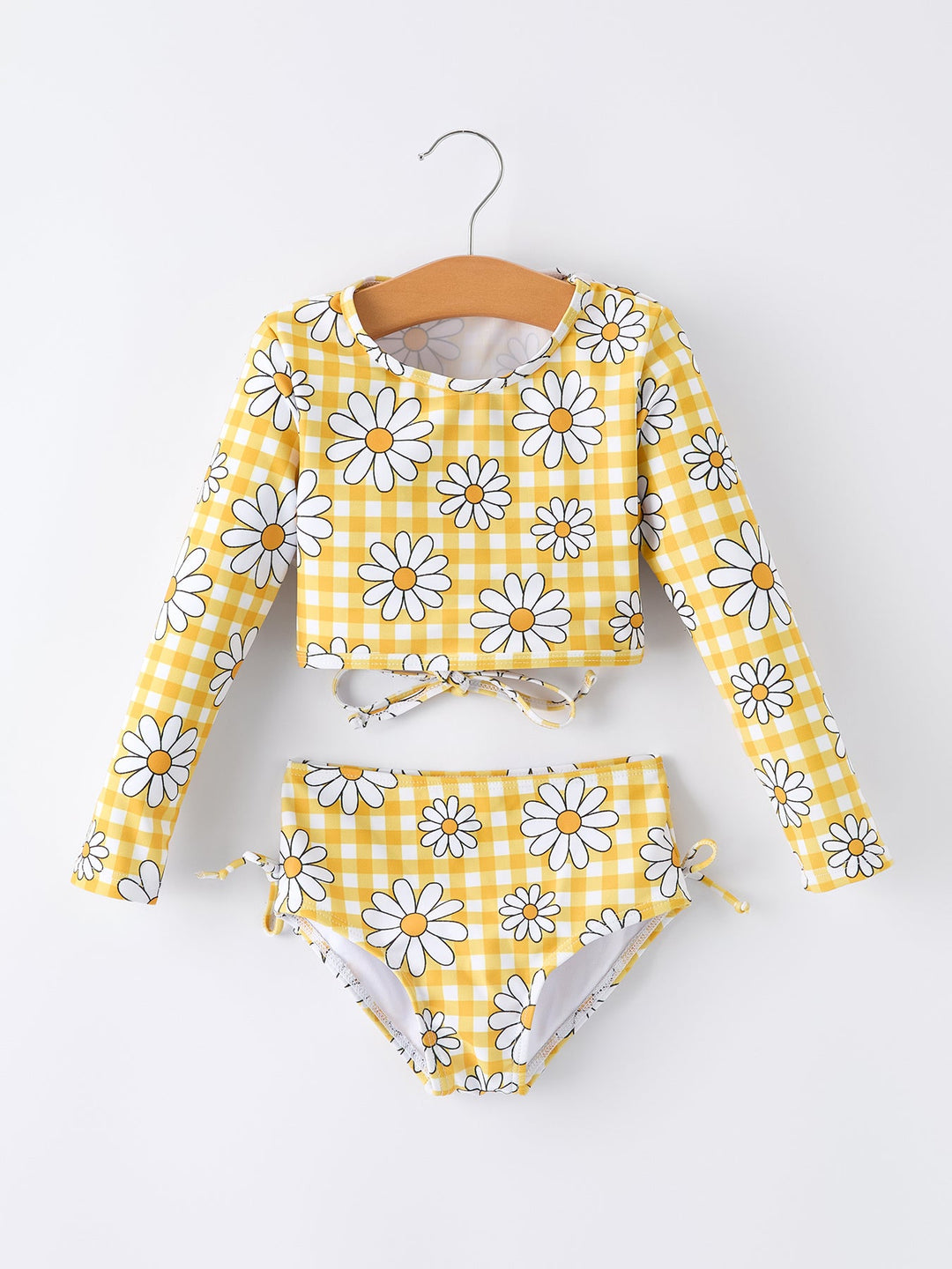 Yellow and white floral bikini set on a hanger against a white background