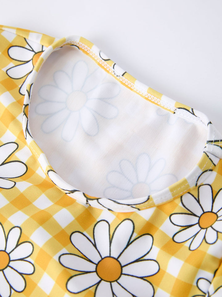 Yellow fabric with white daisies and a white bib on a white background