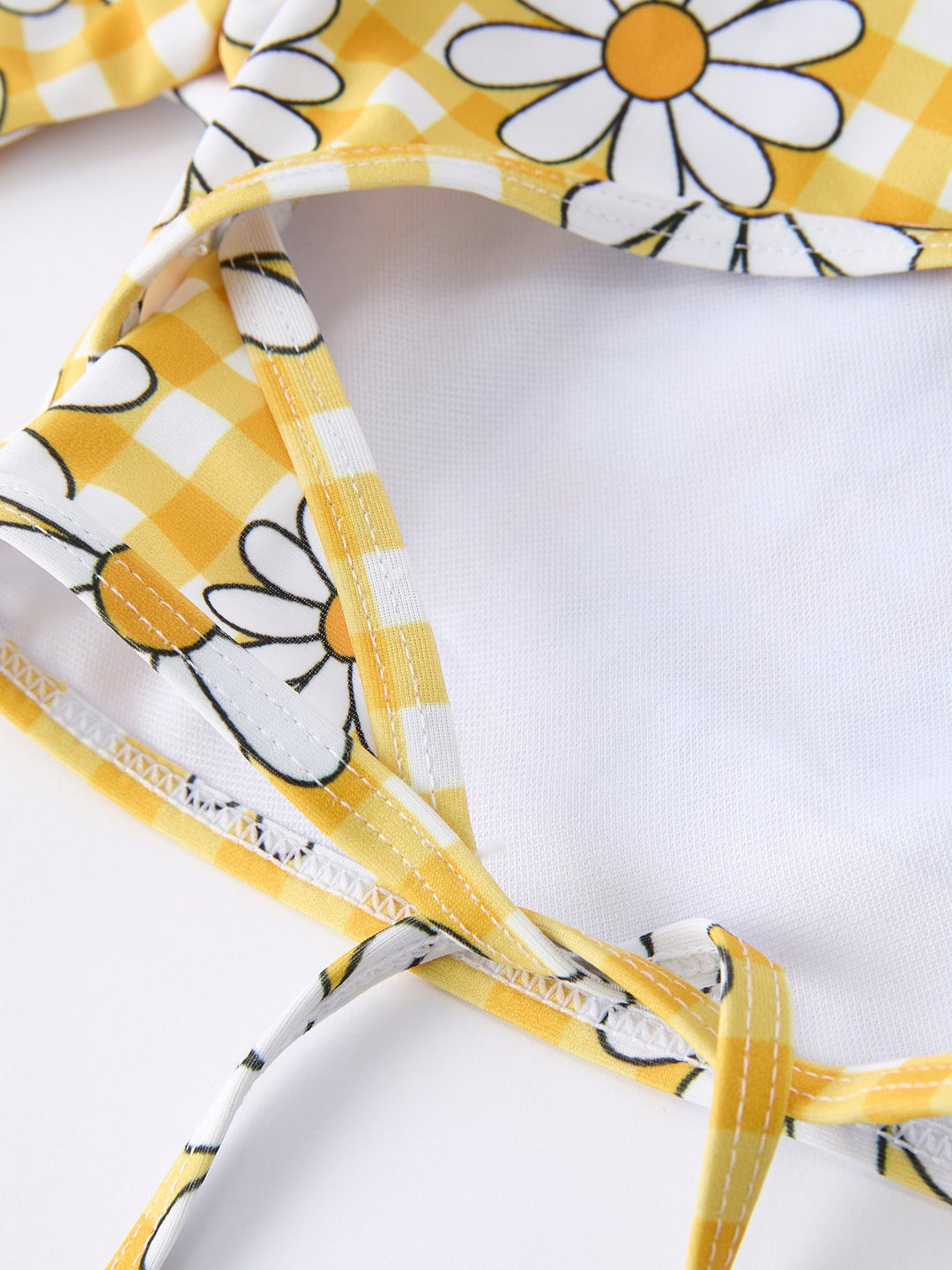 Close-up of a yellow and white floral-patterned headband on a white background