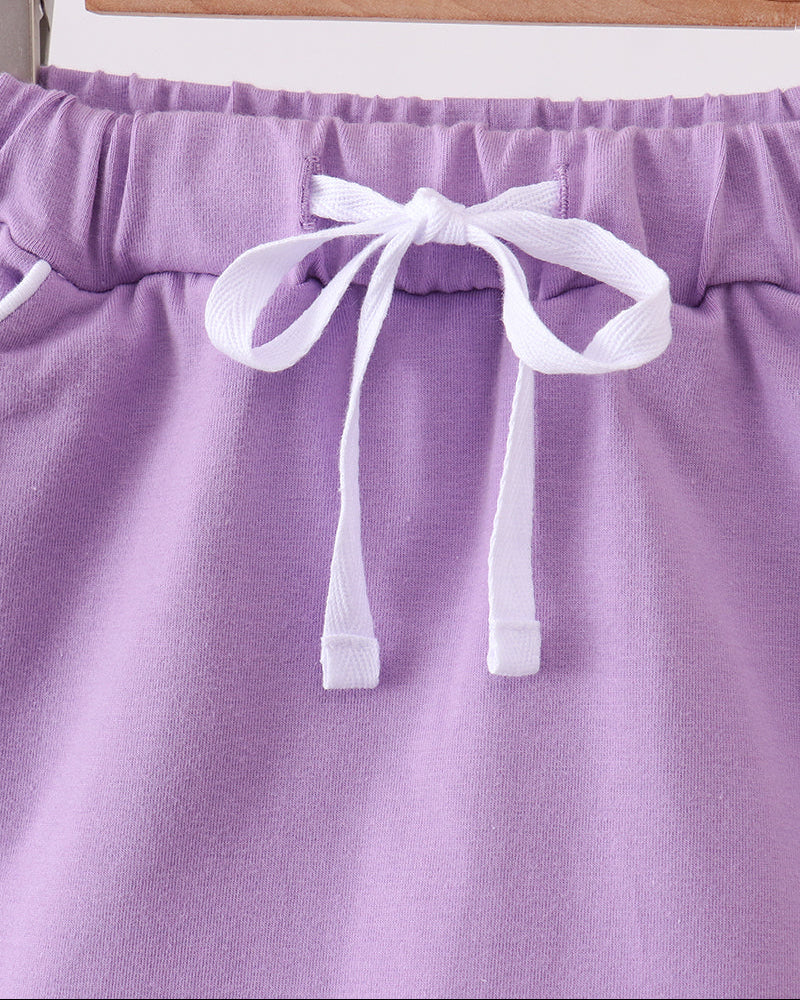 Dark purple skort with elastic waistband and white bow tie detail at front