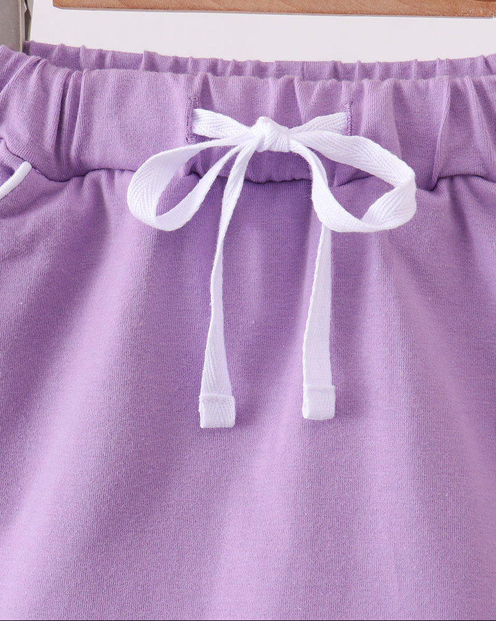 Dark purple skort with elastic waistband and white bow tie detail at front