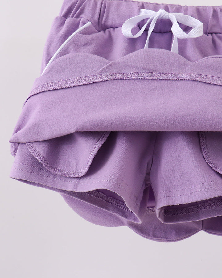 Dark purple skort with scalloped hem and layered shorts underlayer visible