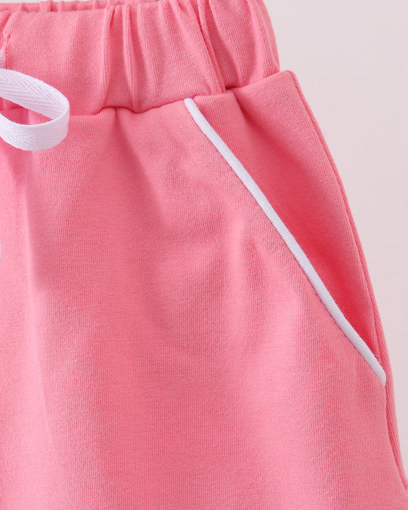 Deep pink skort side view with white drawstring tie and gathered elastic waist