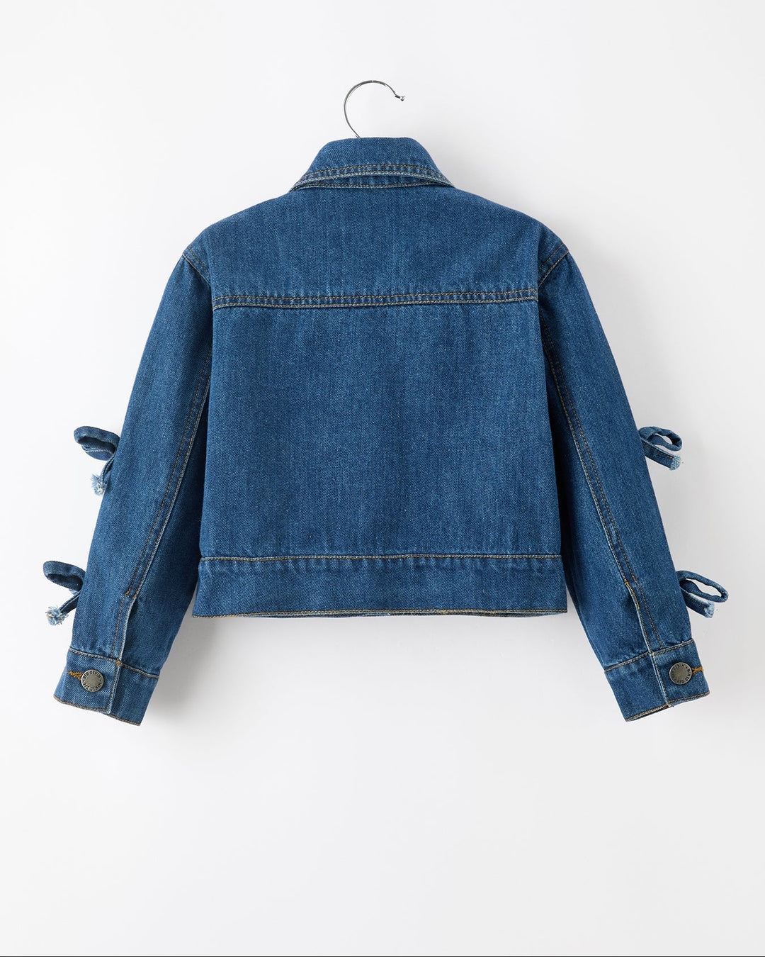 Girls blue denim jacket back view with bow-tie cuff detailing and buttons