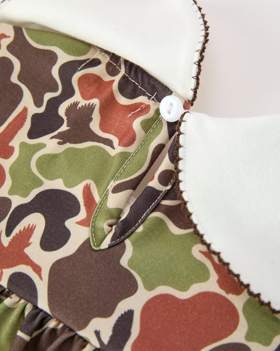 Close-up of a camouflage-patterned fabric with white trim