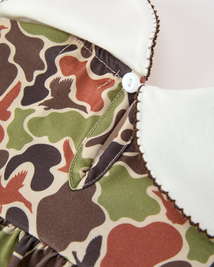 Close-up of a camouflage-patterned fabric with white trim