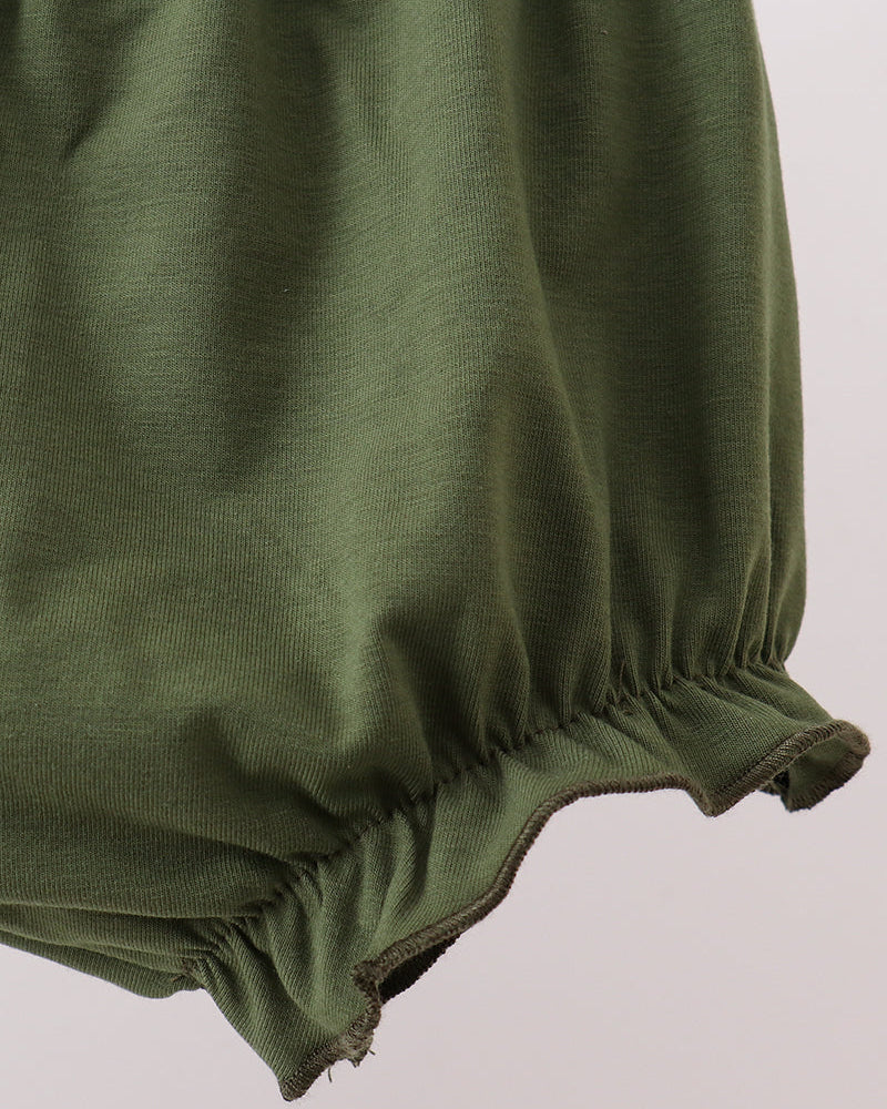 Green fabric with gathered bottom hem on a light gray background
