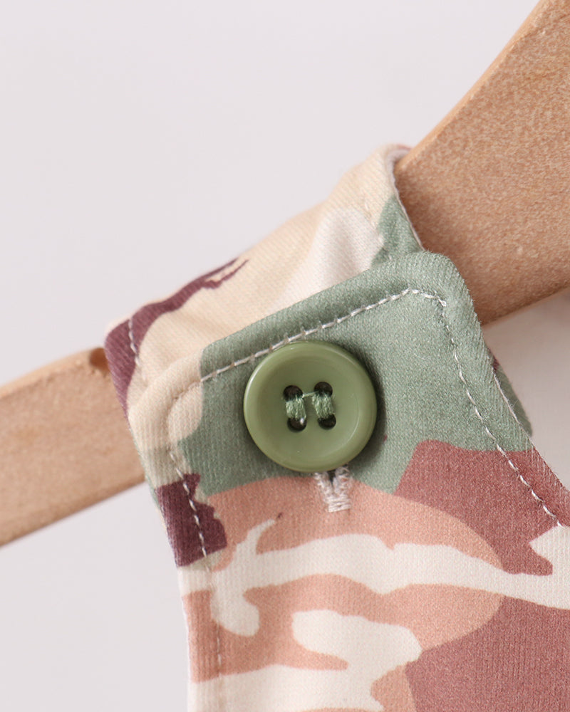 Close-up of a shoulder strap with a button and camouflage pattern on a white background