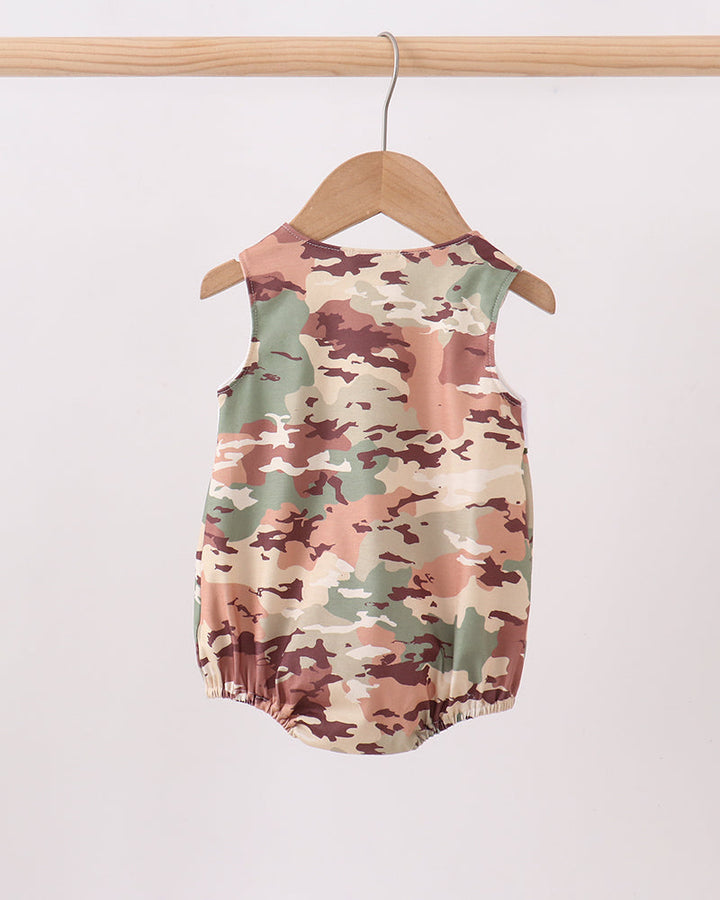 Camouflage-patterned baby romper on a wooden hanger against a white background